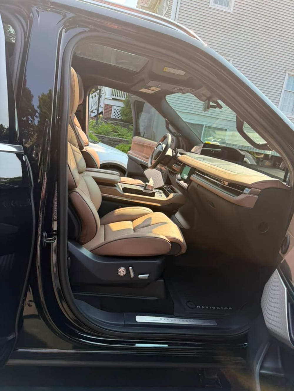 Lincoln Navigator Black Label front seats with quilted cognac leather and wood trim, BLACK LABEL badge on door sill