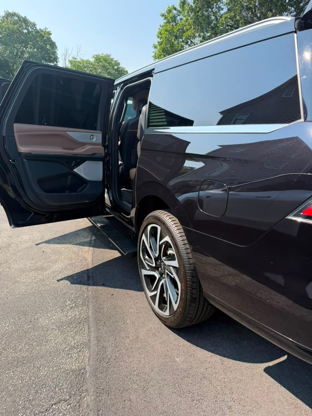 Lincoln Navigator SUV limo side profile showing wheel and open rear door trim